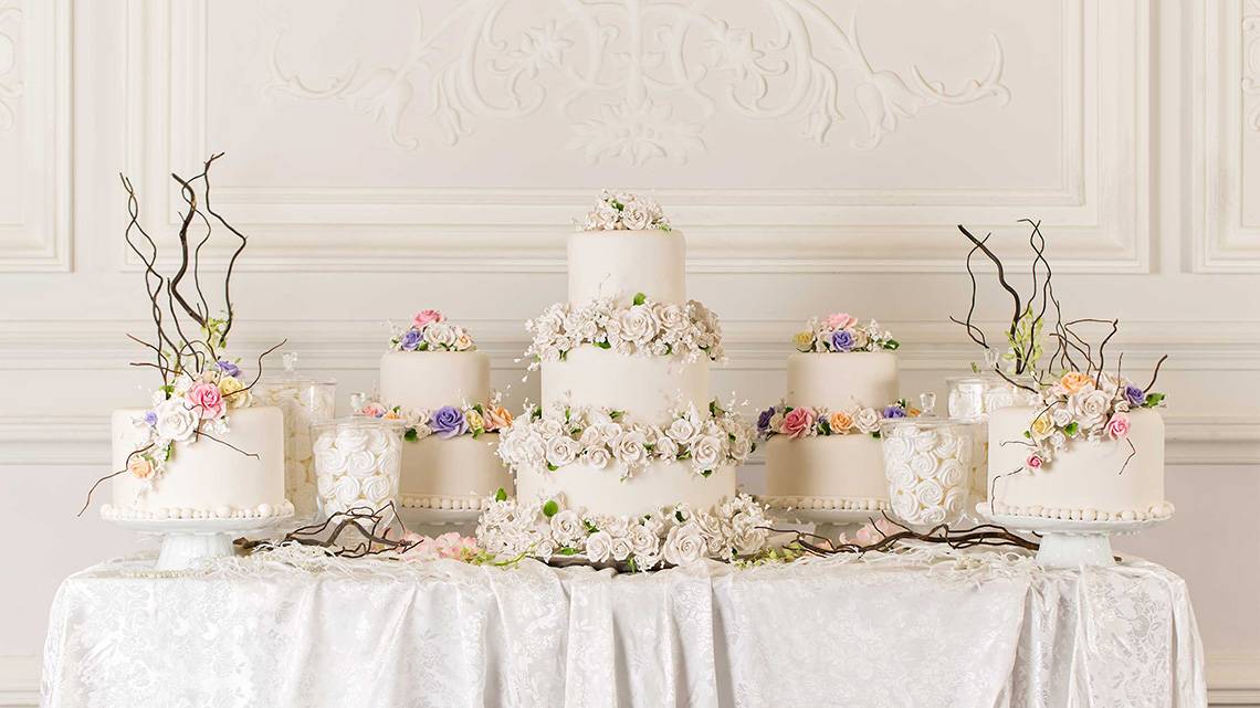 Mehrere Blumen verziert Hochzeitstorten auf einem Tisch im Jumeirah Zabeel Saray
