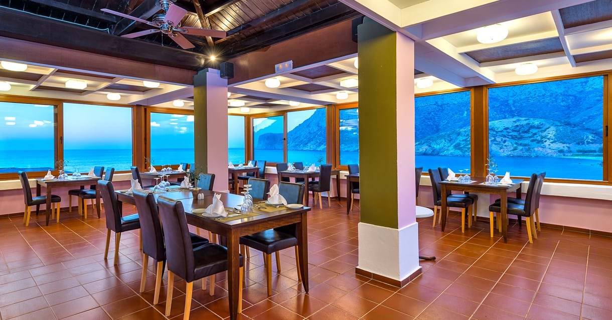 Innenansicht eines Restaurants im Fodele Beach & Water Park Holiday Resort mit Blick auf das Meer.