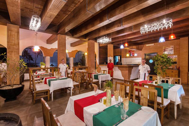Innenbereich des Bahari Zanzibar Hotels, Restaurantbereich mit gedeckten Tischen und freundlichem Personal.