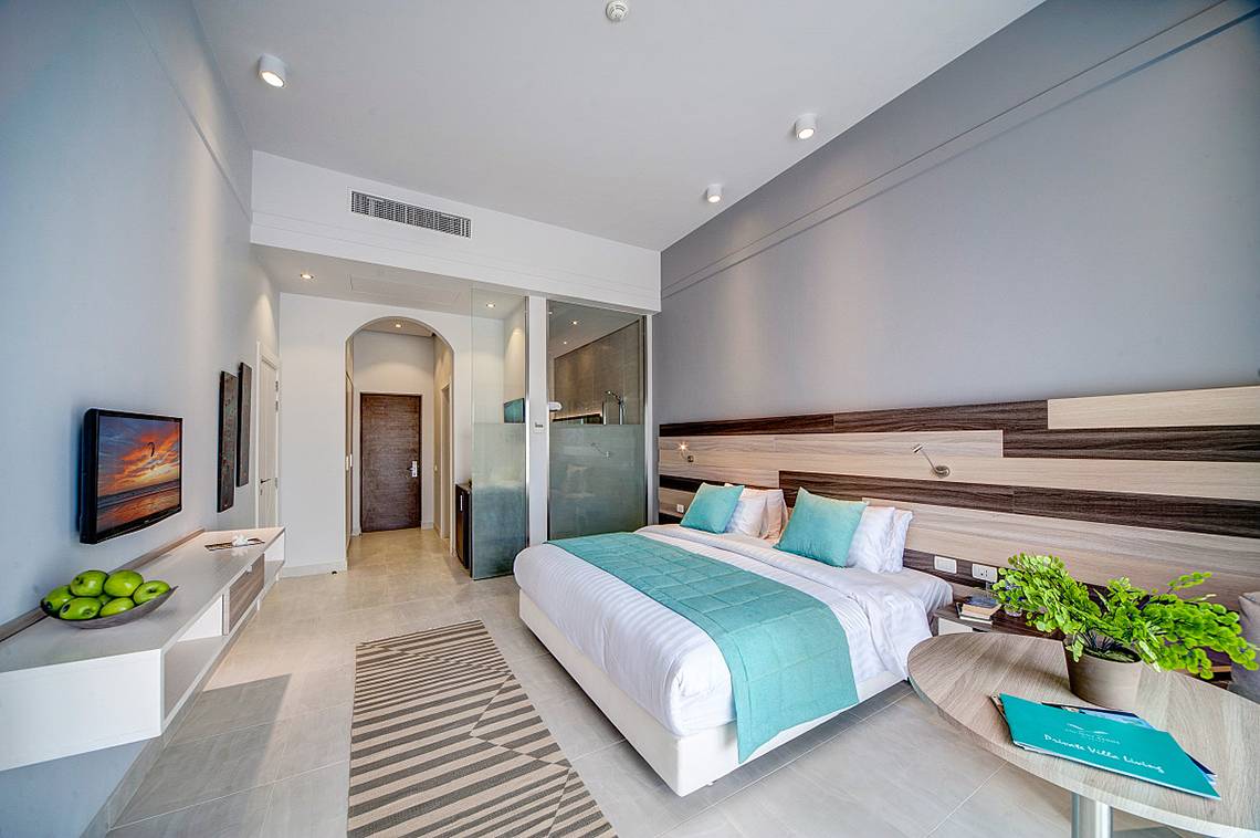 Schlafzimmer im Ancient Sands Golf Resort mit Fernseher und Pflanzen auf dem Tisch