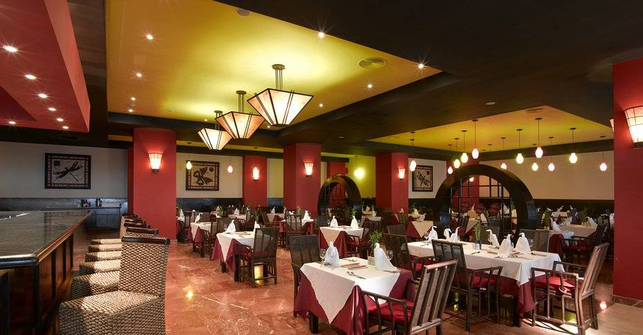 Innenansicht des Restaurants im Grand Palladium Jamaica R. & Spa mit roter und gelber Beleuchtung.
