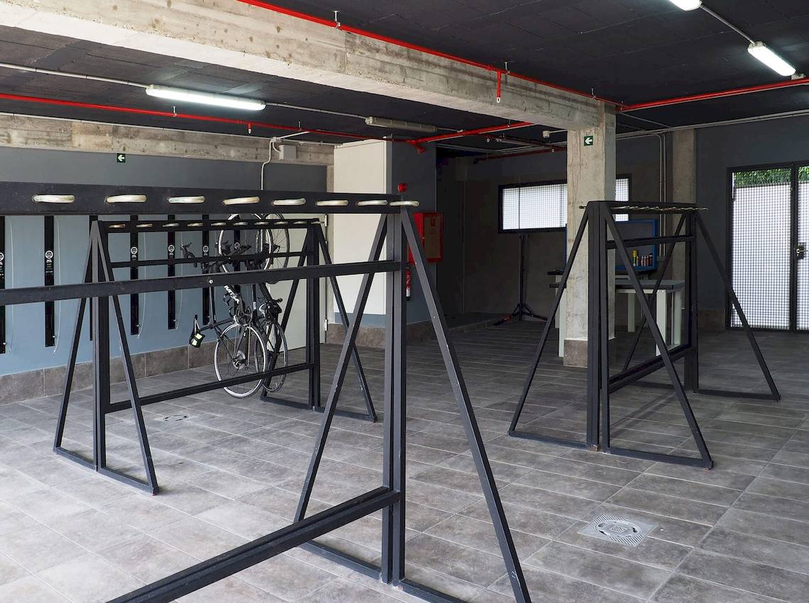 Fahrrad-Abstellplatz im Cosmopolitan Hotel mit Metallständern und einer leeren Wand im Hintergrund.