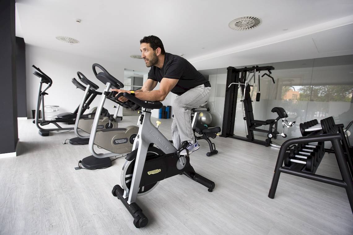 Ein Mann trainiert im Fitnessstudio des Cosmopolitan Hotels auf einem Fahrrad.