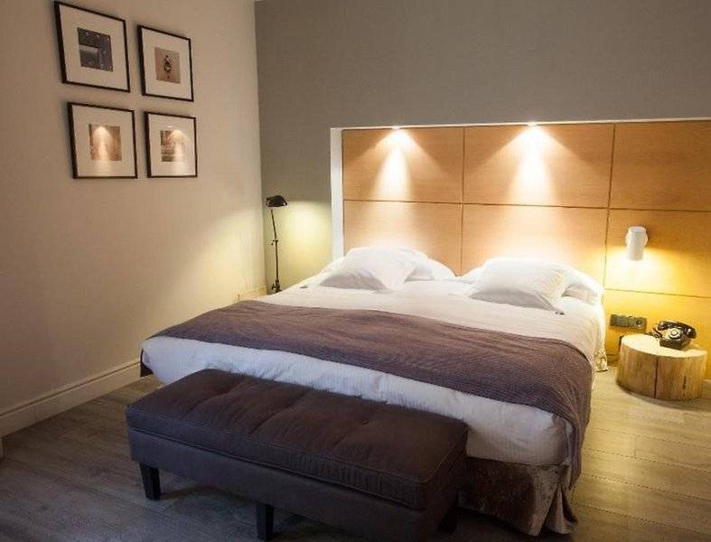 Schlafzimmer im Hotel Barcelona Catedral mit Doppelbett, Nachttisch und Bildern an der Wand.