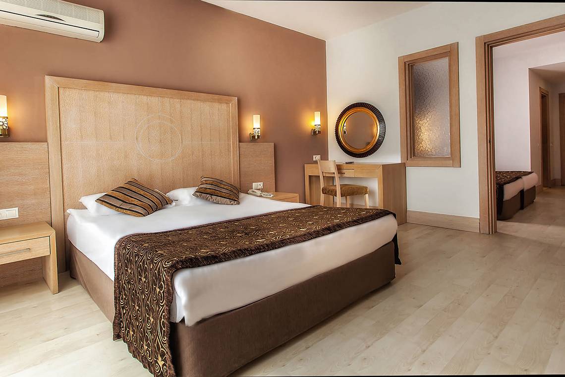 Hotelzimmer im Sultan of Side mit Kingsize-Bett, Dekor und Schreibtisch.