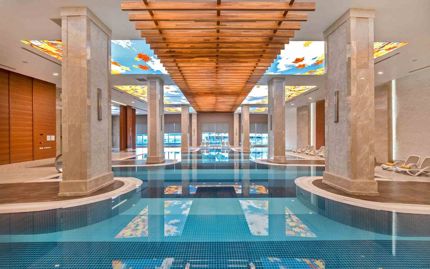 Ein großer Innenpool im Sidemarin Kirman Premium Hotel mit blauem Wasser und bemalten Decken.