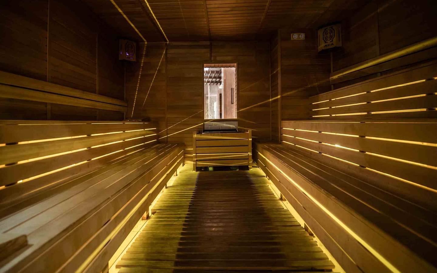 Innenansicht der Sauna im Sidemarin Kirman Premium mit Holzbänken und beleuchteten Wegen.