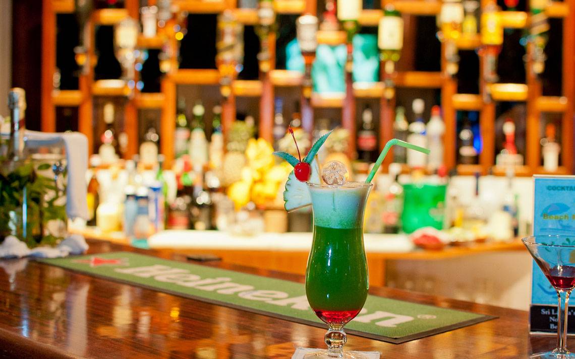 Cocktail Bar im Fihalhohi Island Resort mit grünem Cocktail und grünem Strohhalm.