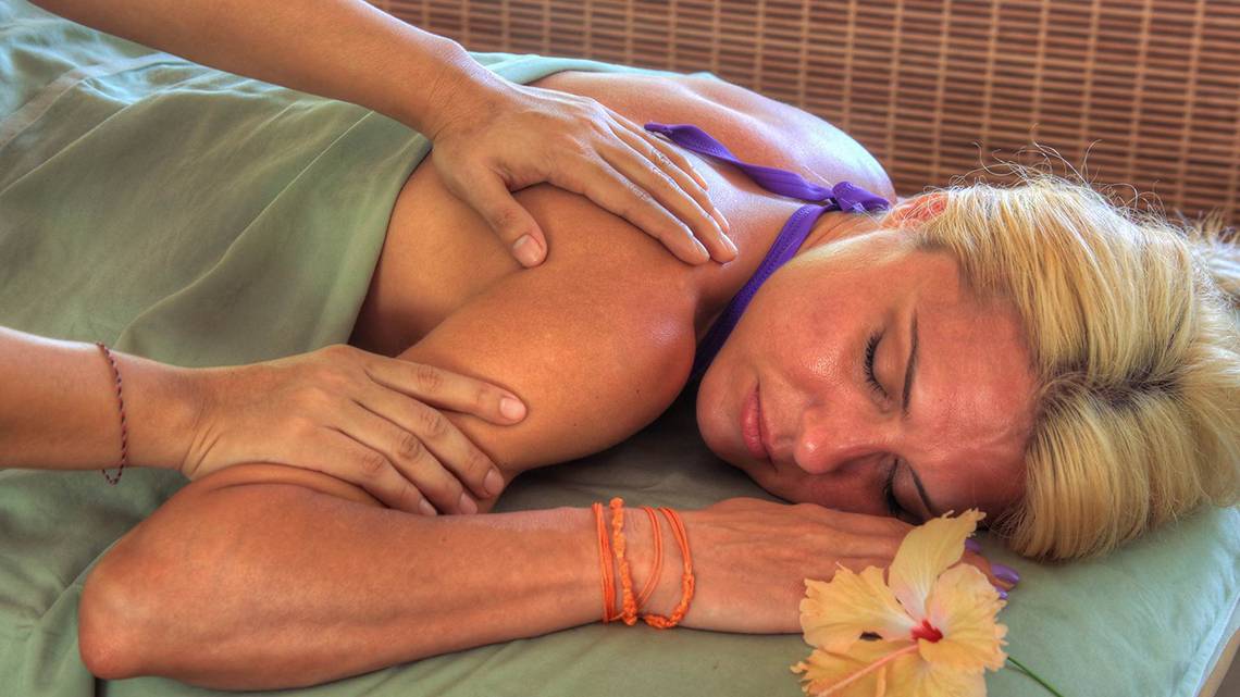 Eine Frau genießt eine Massage im Fihalhohi Island Resort.