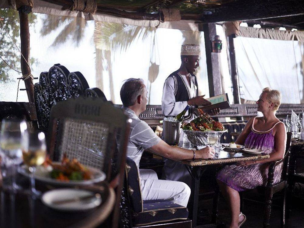 Gäste der Severin Sea Lodge sitzen bei einem Essen an einem Tisch im Freien.