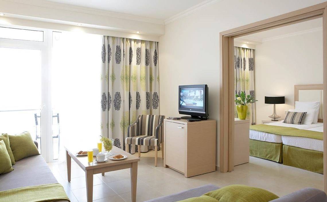 Zimmer im Electra Palace Rhodes Hotel mit Fernseher, Tisch und Bett