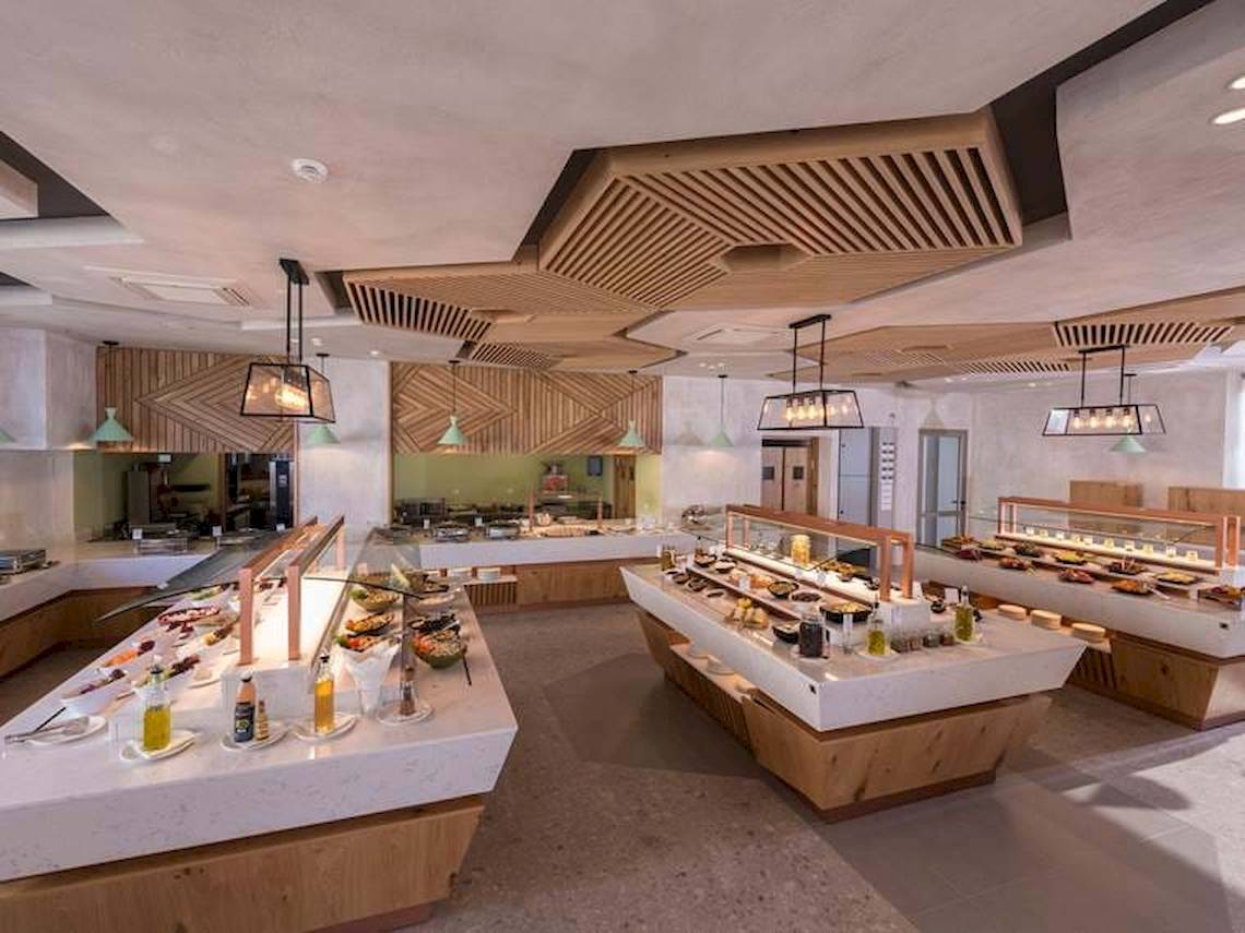 Innenansicht des Restaurants im Cactus Mare Hotel mit vielen Speisen auf Marmortheken.