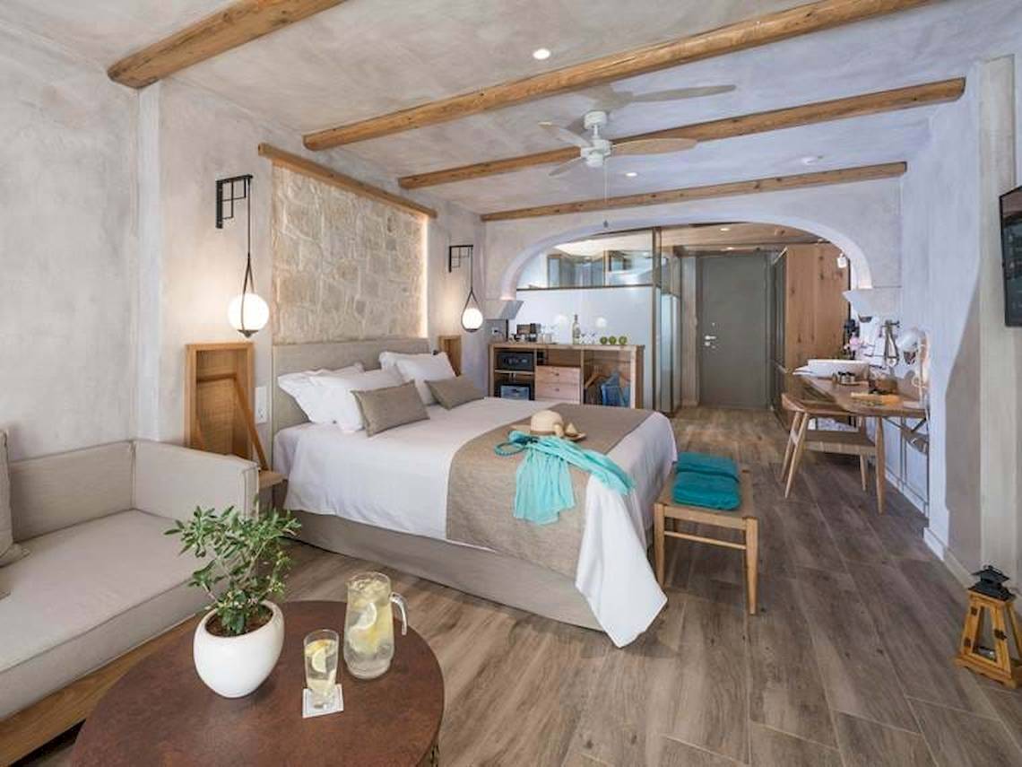 Hotelzimmer im Cactus Mare mit Bett, Couch, Tisch, Lampe, Fernseher und Klimaanlage.