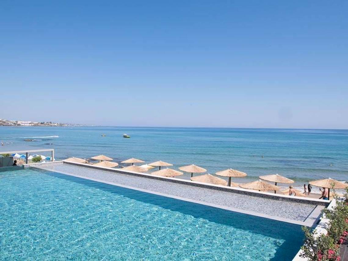 Pool am Strand des Cactus Mare Hotels mit Sonnenschirmen und Gästen.