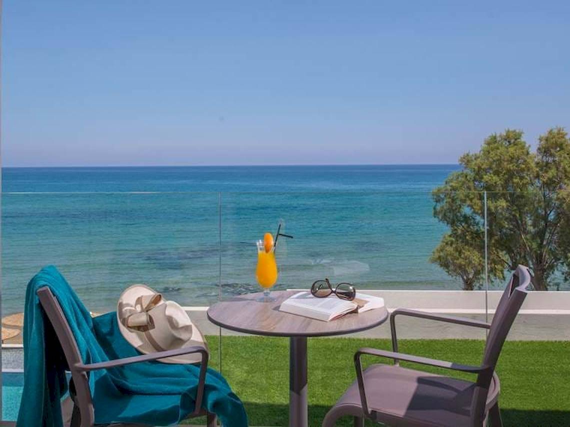Balkon-Ansicht auf das Meer im Hotel Cactus Mare mit einem Glas Orangensaft und einer Bucht.