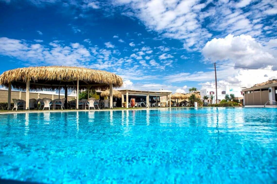 Außenpool des Plaza Beach Hotels mit Sonnenschirmen und Lounge-Stuhl.
