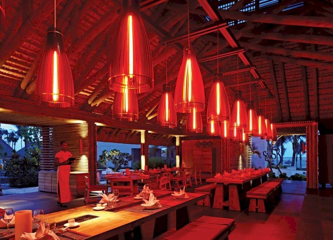 Innenbereich des Long Beach Mauritius Restaurants mit roten Leuchten und gedeckten Tischen.