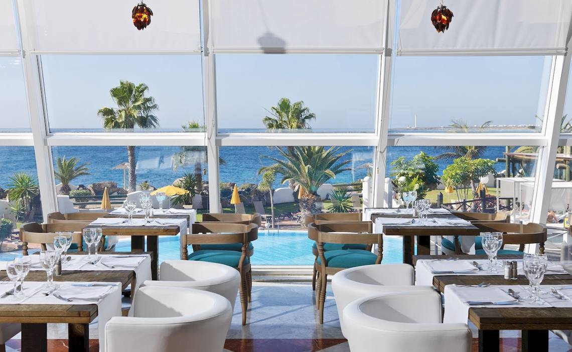 Innenansicht des Restaurants des H10 Timanfaya Palace mit Blick auf den Pool und das Meer