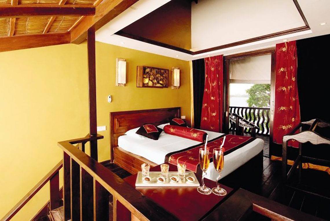 Zimmer im Cinnamon Dhonveli Maldives mit Bett, Fenster und Aussicht auf Wasser.