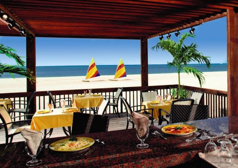 Terrasse des Divi Tamarijn Aruba mit Blick auf das Meer und Segelboote.