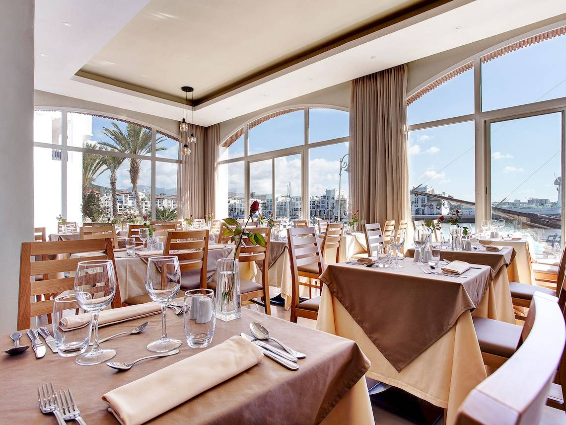 Innenansicht des Restaurants im Bianca Beach Resort mit Blick auf die Stadt und den Hafen.