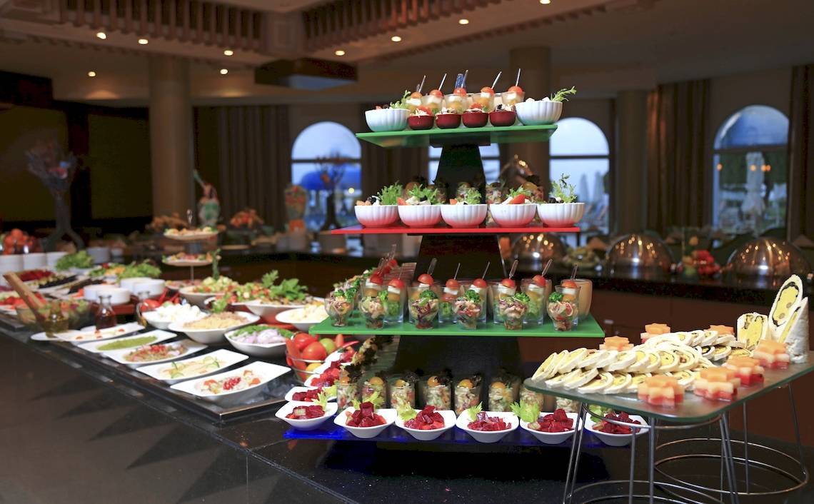 Buffet-Tisch im Wyndham Garden Salalah Mirbat mit verschiedenen Gerichten auf mehreren Etagen.