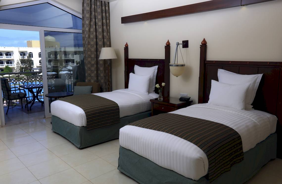 Zwei Betten im Zimmer mit Balkon im Wyndham Garden Salalah Mirbat Hotel