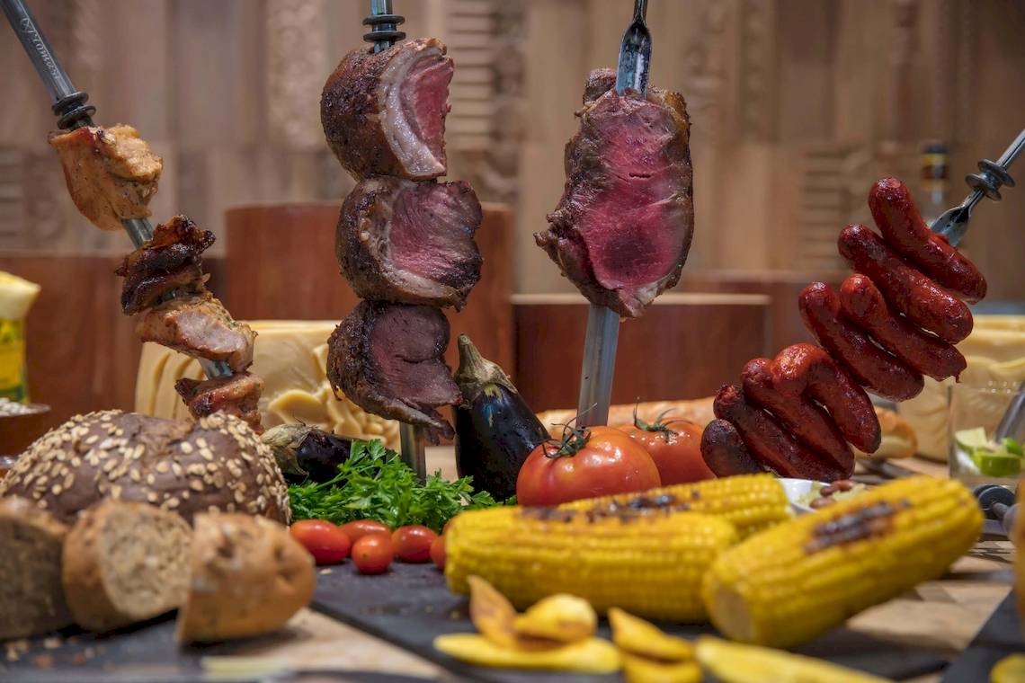 Gegrilltes Fleisch und Gemüse auf einem Buffet serviert.