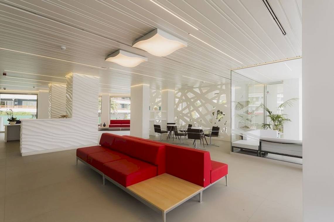 Innenbereich des Caserio Hotels mit rotem Sofa, Tisch und modernen Möbeln.