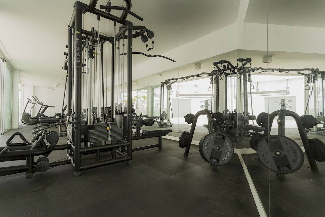Innenansicht des Fitnesscenters im Caserio Hotel mit verschiedenen Trainingsgeräten und Geräten.