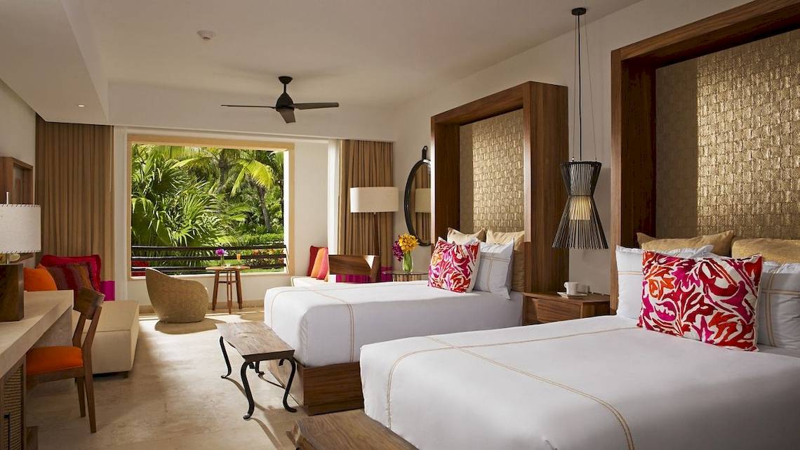 Suite im Secrets Akumal Riviera Maya Hotel mit zwei Betten, Balkon und tropischer Aussicht