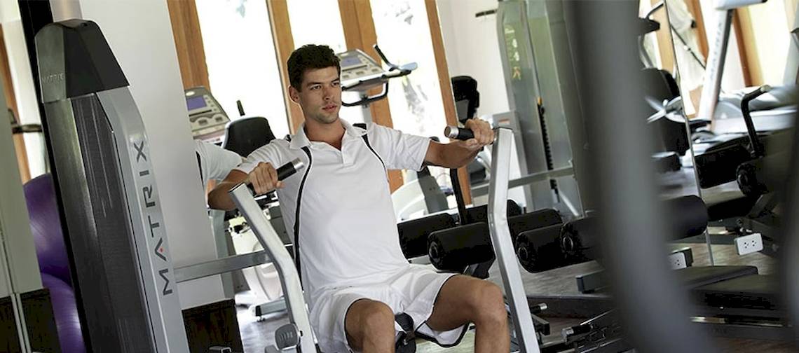 Ein Mann trainiert im Fitnessstudio des Holiday Inn Mai Khao Resort.