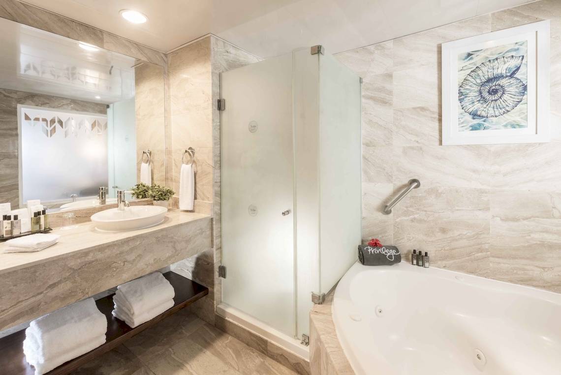 Badezimmer im Ocean Blue & Sand by H10 mit Badewanne, Dusche und Waschbecken.