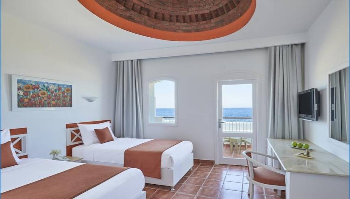 Hotelzimmer mit zwei Betten, Blick auf das Meer und Balkon.