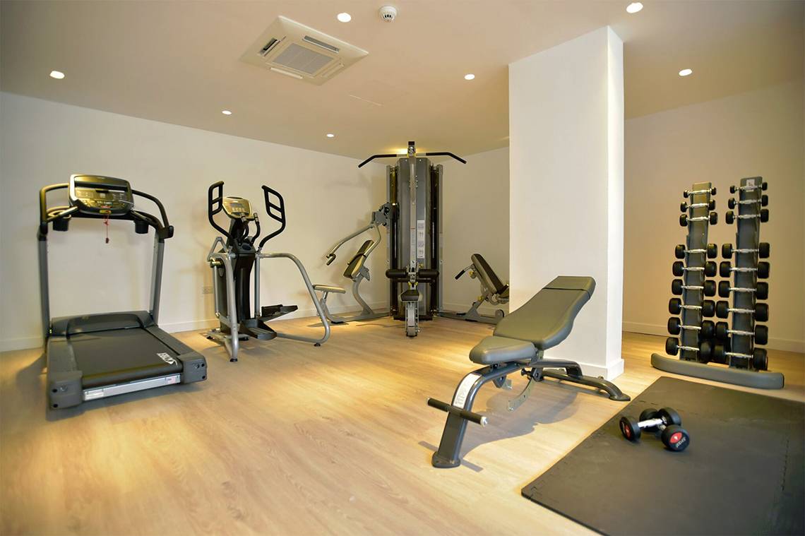 Fitnessraum im Sunrise Gardens Hotel mit Laufband, Crosstrainer, Hantelbank und Hanteln.