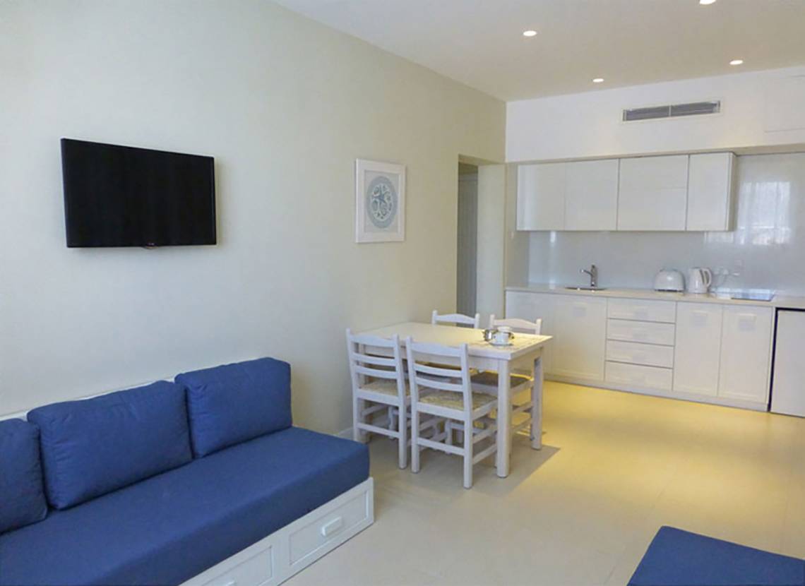 Wohnzimmer mit Tisch und Sofa in Sunrise Gardens Hotel.
