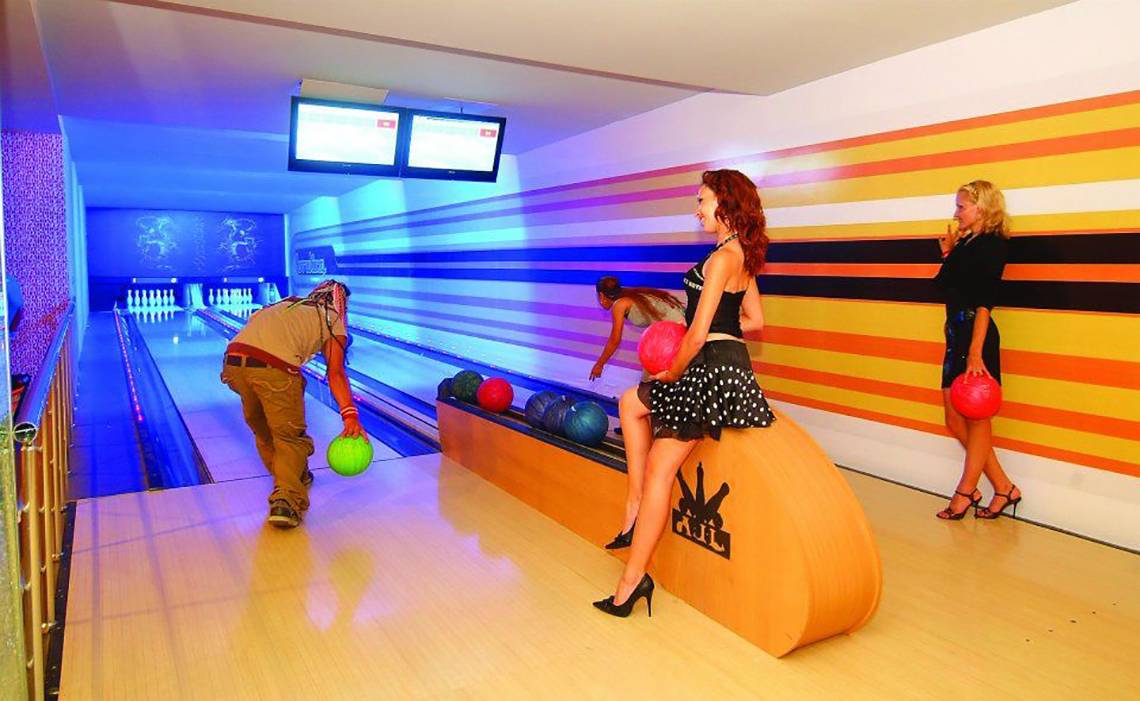 Royal Dragon Hotel Bowlinghalle mit bunten Wänden und Spielenden.