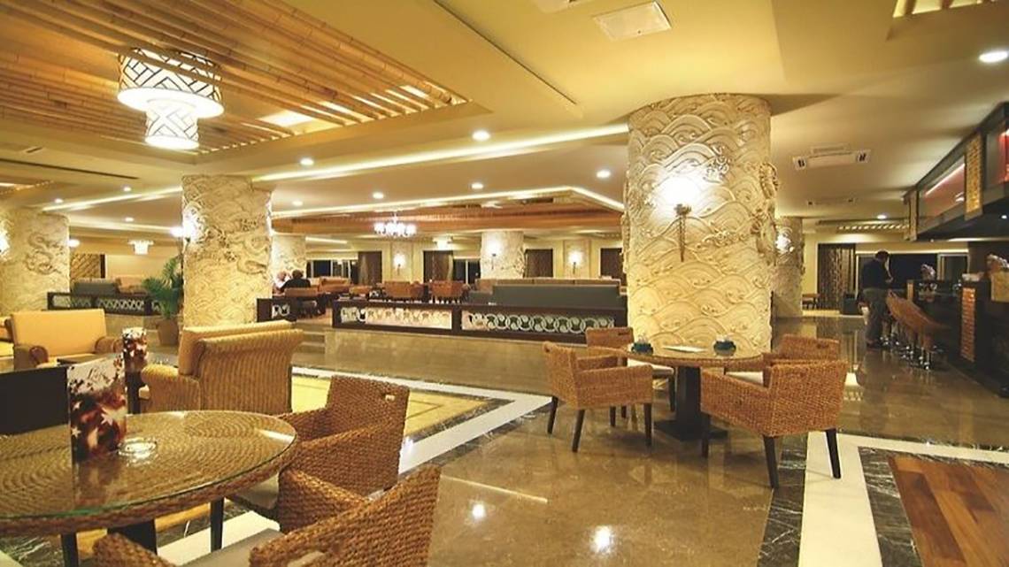 Lobby des Royal Dragon Hotels mit Sitzgelegenheiten und hohen Säulen.