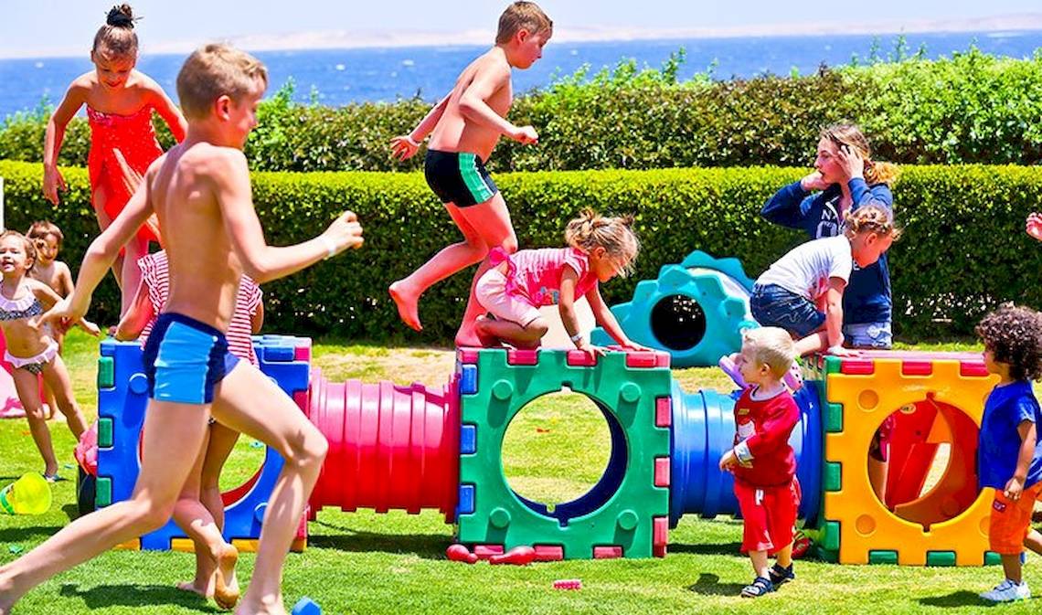 Kinder spielen in einem Freizeitpark mit bunten Spielgeräten.