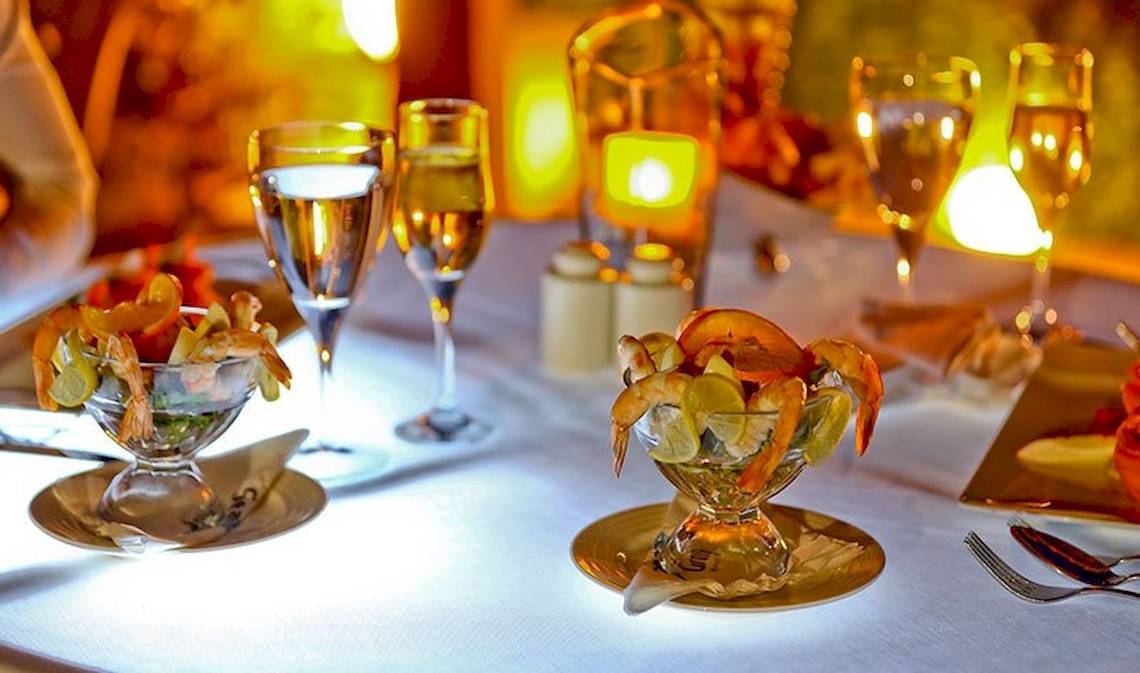 Dinnertisch im Charmillion Club Resort mit Vorspeisen, Wein und Kerzen.