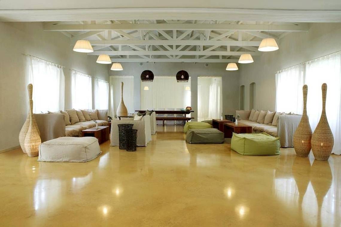 Innenbereich des Doryssa Seaside Resort mit Sofas, Sitzkissen und Tischlampen.