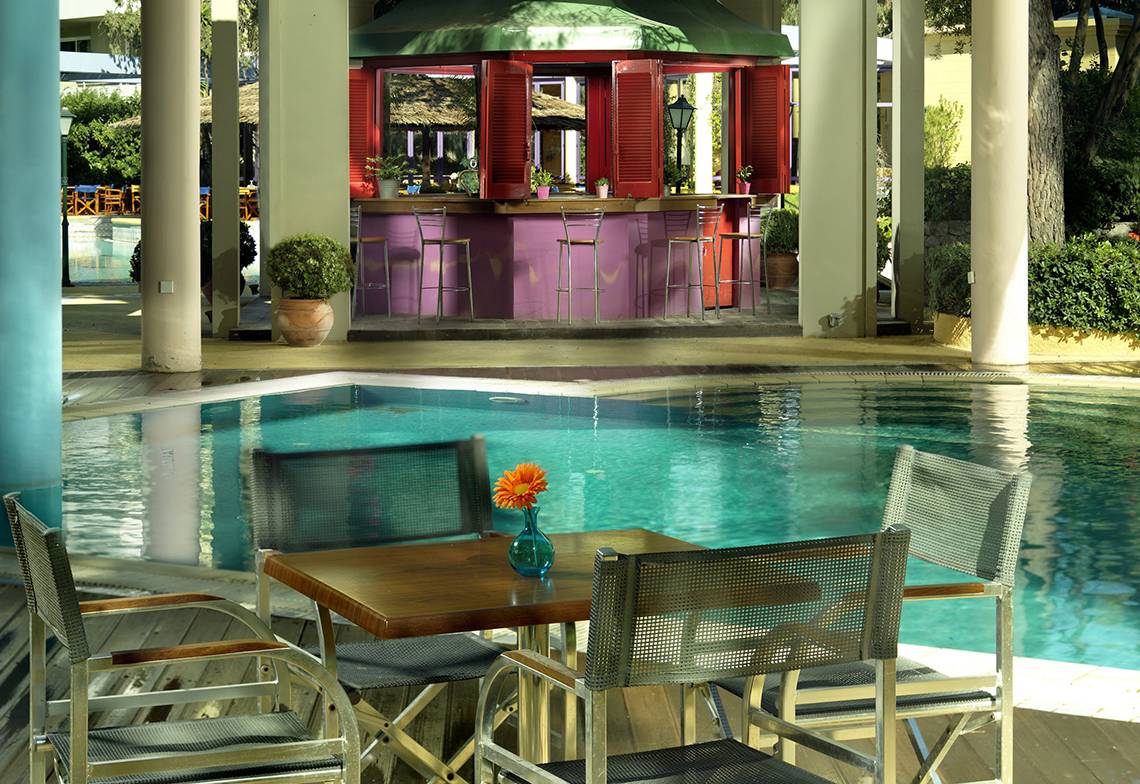 Poolbereich des Dionysos Hotels mit Bar und Tischen am Pool