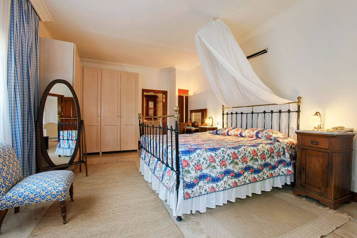 Ein Schlafzimmer mit einem Bett, Spiegel und Stuhl im Marti Myra Hotel.