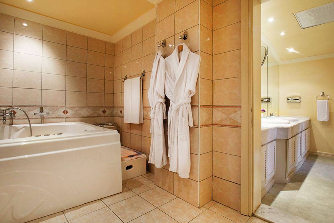 Badezimmer im Hotel Marti Myra mit Badewanne, Handtüchern und Waschbecken.