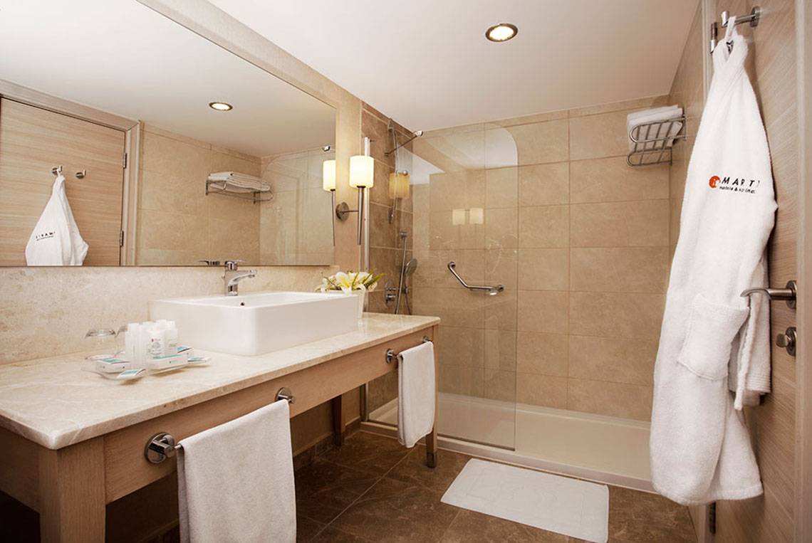 Badezimmer im Marti Myra Hotel mit Marmorboden, Dusche und Waschbecken.