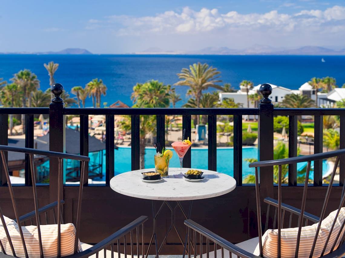 Terrasse des H10 Rubicon Palace mit Blick auf das Meer und Cocktails auf dem Tisch.