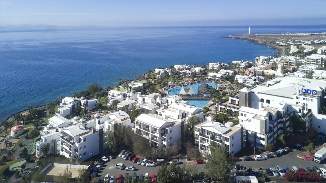 Luftaufnahme des H10 Rubicon Palace Hotels mit Pool und Meer im Hintergrund.