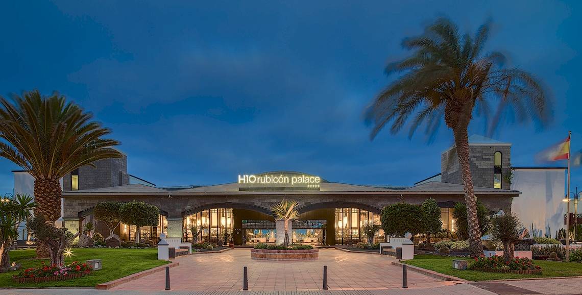 Außenansicht des H10 Rubicon Palace Hotels bei Nacht mit Beleuchtung und Palmen