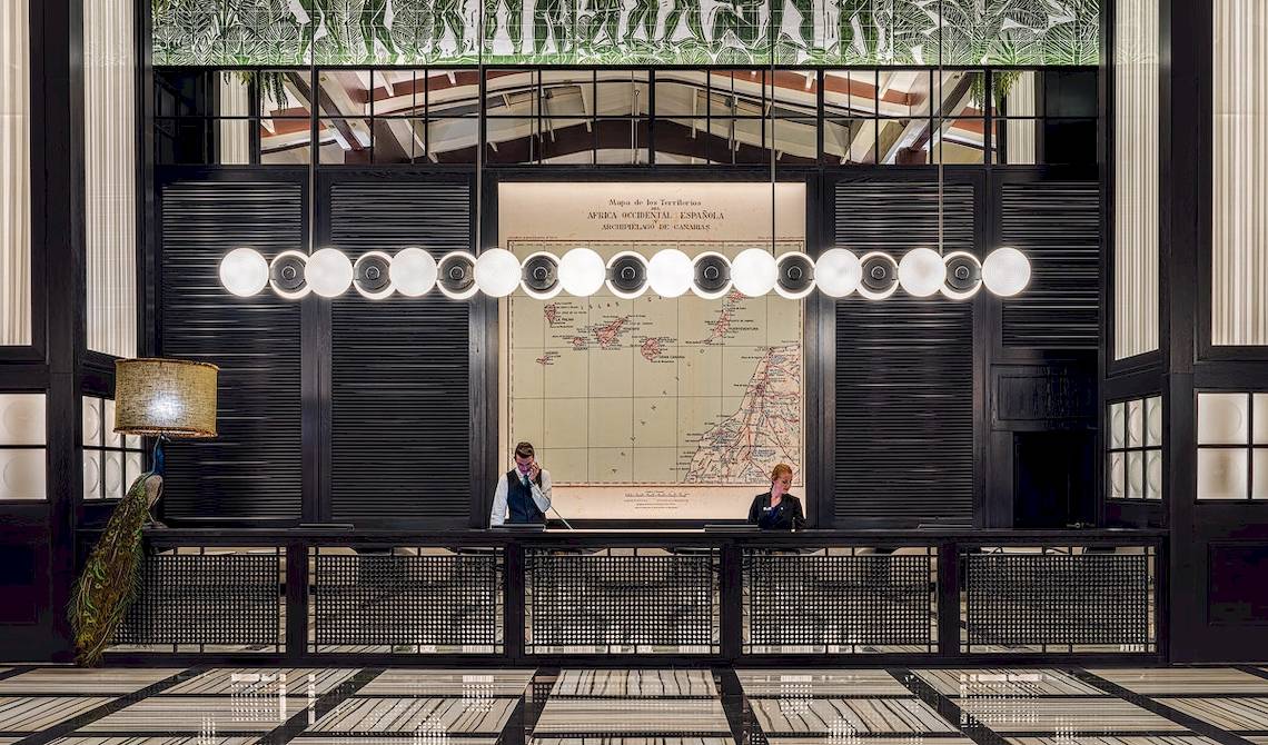 Empfangshalle des H10 Rubicon Palace mit zwei Mitarbeitern und einer Karte