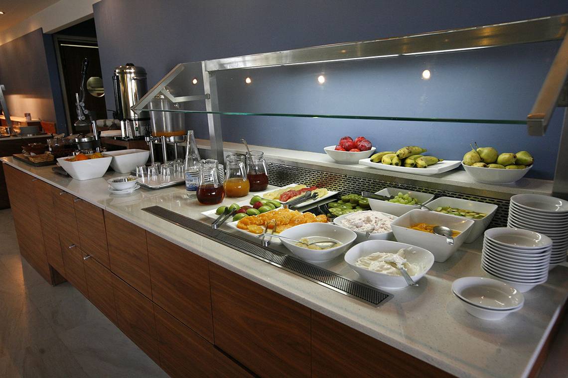 Buffettisch im Minos Mare Royal Hotel mit verschiedenen Früchten, Joghurt und Säften.